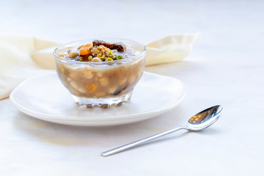 Traditional Turkish Dessert Aşure or Noah's Pudding with ingredients on white in stylish bowl: Aşure "Turkish Cuisine"
