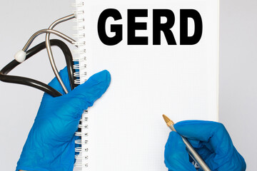 The doctor's blue - gloved hands show the word GERD - . a gloved hand on a white background. Medical concept. the medicine