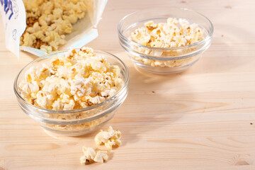 crispy golden ready to eat popcorn in a glass bowl. close up shot. 