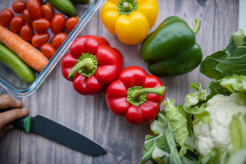 Fresh and colorful bell peppers and other vegetables on wooden table