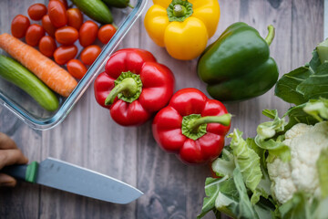 Fresh and colorful bell peppers and other vegetables on wooden table