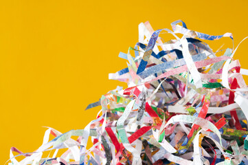 Closeup shredded paper texture and reuse colorful paper scrap of document on yellow paper background. Selective focus image.
