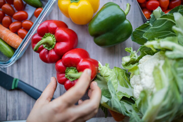 Fresh and colorful bell peppers and other vegetables on wooden table