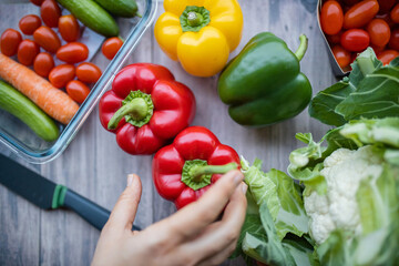 Fresh and colorful bell peppers and other vegetables on wooden table