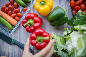 Fresh and colorful bell peppers and other vegetables on wooden table