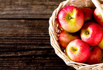 apples in a basket on a wooden background