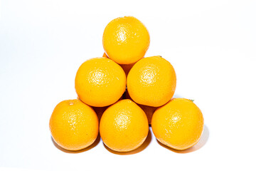 Pyramid of orange ripe tangerines on a white background