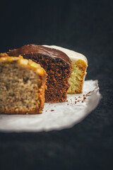 Slices of chocolate bread, banana bread, and lemon bread on rustic paper.