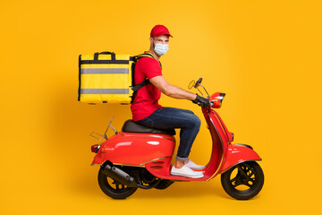 Profile photo of delivery man ride scooter wear bag gloves mask red t-shirt cap jeans sneakers isolated yellow color background © deagreez