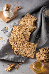 whole grain crispbread with curd cheese and honey on a gray towel