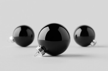Three black glossy Christmas balls mockup on a seamless grey background.