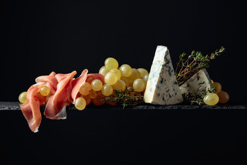 Mediterranean snacks. Grapes with blue cheese, prosciutto and thyme.
