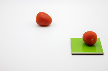 tomatoes on colored coasters and white background