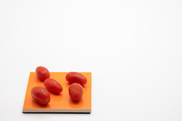 tomatoes on colored coasters and white background