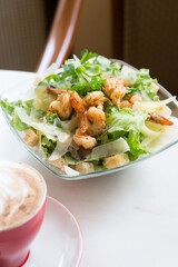 Caesar salad with shrimps served for lunch