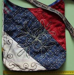The bag is made in patchwork style from multi-colored pieces of fabric and decorated with embroidery