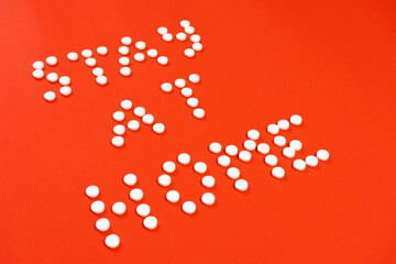 Stay home lettering made from round white pills. Red background