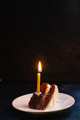 cake slice of chocolate cake with cream and biscuit and the candle is burning celebration birthday or anniversary event on the table meal ingredient top view copy space for text food background rustic