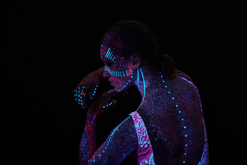 Art woman cosmos in ultraviolet light. Entire body is covered with colored droplets. Girl posing in...