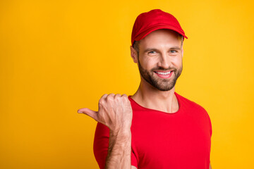 Photo of bristled man direct thumb back empty space wear red t-shirt cap isolated yellow color...