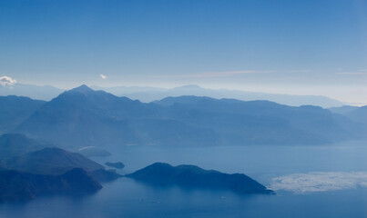 view from the airplane window of the mountains and clouds.