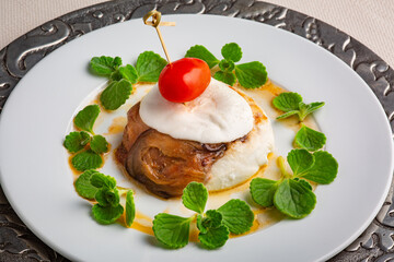 Portion of mozzarella alla parmigiana di melanzane with tomato on white background, close up