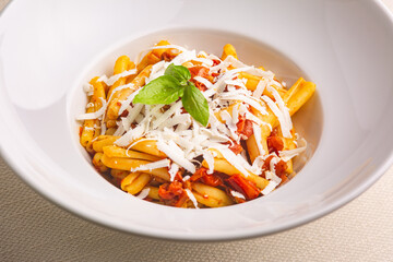 Casarecce pasta withe cherry tomatoes, parmesan cheese and fresh basil on white background. Close up