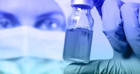 Doctor hand in protective medical gloves and anesthesia liquid bottle on white table lab. Preparation in operation concept. Protection against contagious disease, coronavirus.
