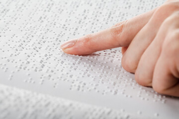 A woman reads a book written in Braille.