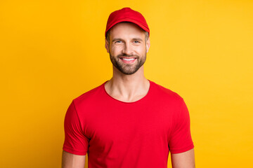 Photo of cheerful young bristled guy toothy beaming smile look camera wear red t-shirt cap isolated...