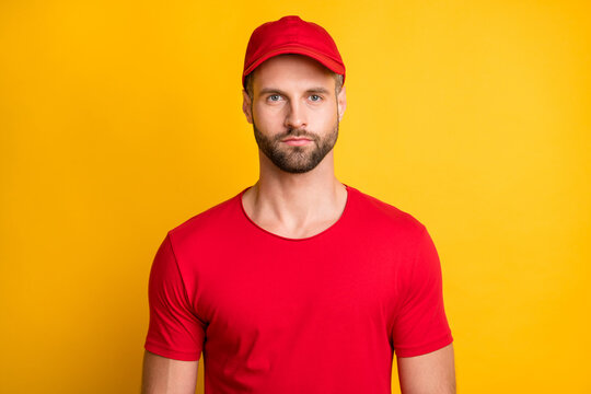 Photo Of Charming Calm Young Bearded Man Serious Look Camera Wear Red T-shirt Headwear Isolated Yellow Color Background