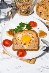 fried egg in a heart shape in toast for breakfast, vertical