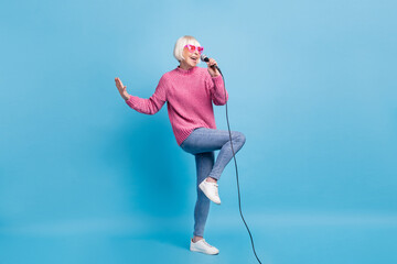 Full length photo portrait of woman standing on one leg singing holding microphone in one hand...