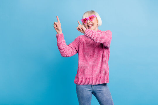 Photo portrait of cheerful old lady wearing rose-tinted glasses dancing isolated on pastel blue colored background
