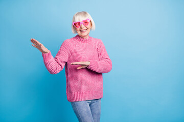 Photo portrait of old woman dancing with pink glasses isolated on pastel blue colored background