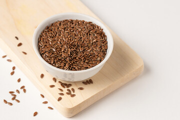 Raw flax seeds in ceramic bowl on white background for Superfood and diet product concept