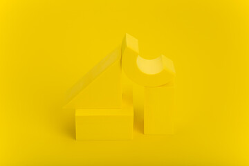 Monochromatic still life composition with geometric objects. High angle view of yellow figures on a...