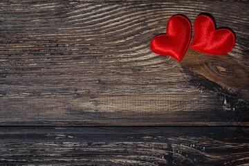 two red hearts on a dark wooden background, horizontal photo top view