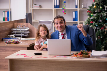 Young male employee celebrating Christmas at workplace with his