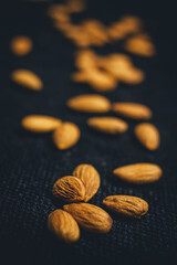 Raw almonds on dark background.