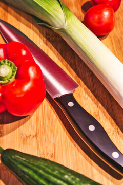 Vegetarian and vegan cooking with fresh vegetables. Leek, tomatoes, cucumber and paprika are freshly cut. Healthy and homemade cooking.
