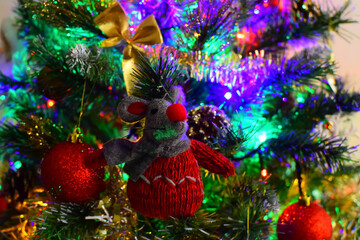 Christmas toy rat on a Christmas tree decorated with a garland