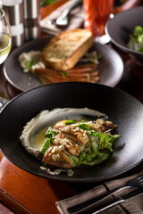 roasted duck breast with almond and lettuce on wooden table at restaurant
