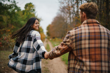 Cheerful couple smiling and holding hands together while strolling