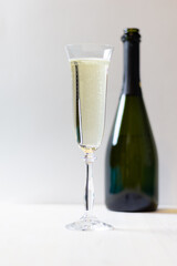 Glass with champagne an bottle on white background