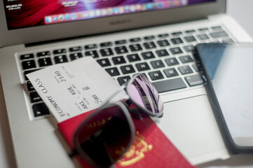 Planning a trip. Passport, Smartphone, Sunglass, Printed Boarding Pass and Laptop.
Top view.
Selective focus.