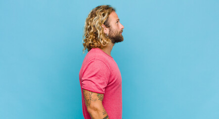 blonde man on profile view looking to copy space ahead, thinking, imagining or daydreaming