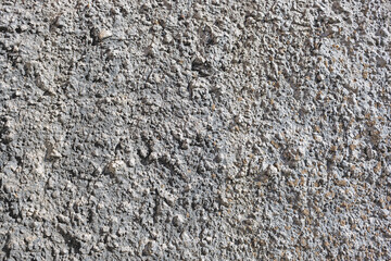 Bumpy derelict crushing ground, massive dense arid layer. Gray gritty cement fractured mortar, cracked stiff boulders. Grooved gully dirty pitted crust of rough rugged grunge broken chipped dried mass