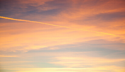 Sunset sky. Texture of bright evening sky during sunset. Dramatic blue and orange, colorful clouds at twilight time. Abstract weather nature background.
