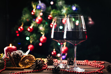 Glasses of wine on the background of a decorated Christmas tree. New Year